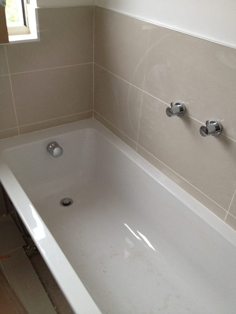 new bathtub installation with controls on wall