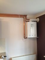 small white gas boiler installation in corner of a room
