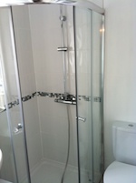 curved two door shower cubicle and white tiles