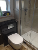 shower cubicle and new white toilet with water tank hidden